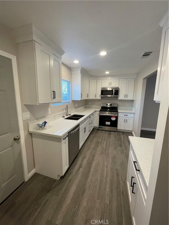 kitchen with white cabinetry, sink, dark hardwood / wood-style flooring, and stainless steel appliances