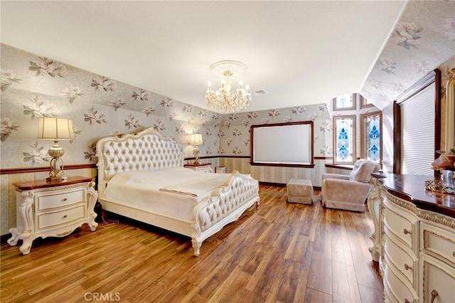 bedroom with hardwood / wood-style flooring and a notable chandelier