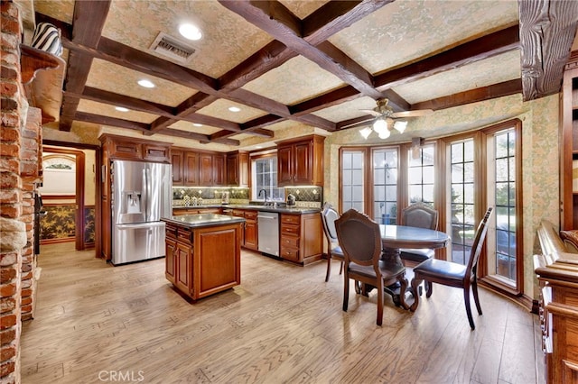 kitchen featuring stainless steel appliances, a center island, light hardwood / wood-style flooring, and backsplash