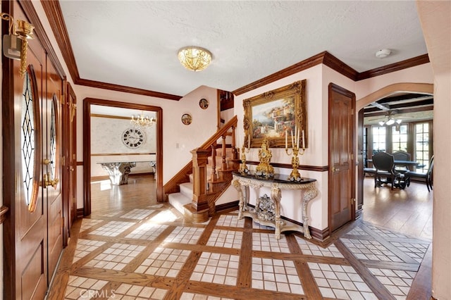 entryway with light tile patterned flooring, a textured ceiling, and a chandelier