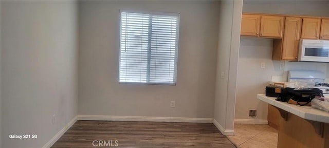 kitchen with tile patterned flooring, tile counters, and light brown cabinets