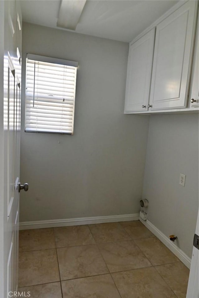 washroom with light tile patterned flooring and cabinets