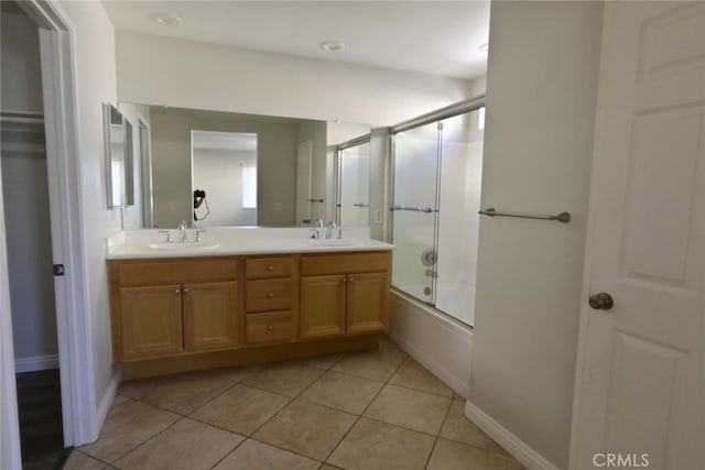 bathroom featuring enclosed tub / shower combo, tile patterned floors, and vanity