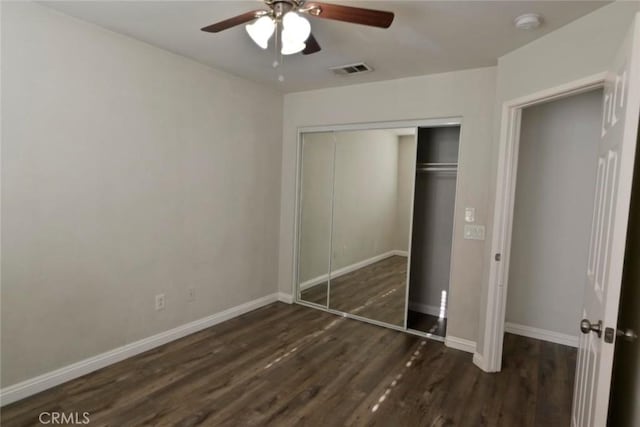 unfurnished bedroom with dark hardwood / wood-style floors, a closet, and ceiling fan