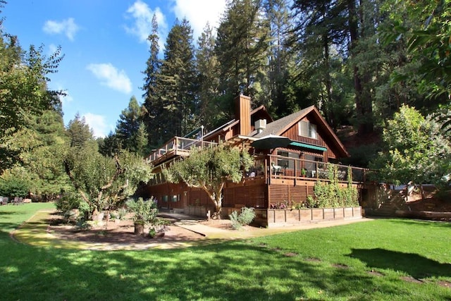 back of house with a wooden deck and a yard