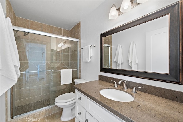 bathroom featuring an enclosed shower, vanity, tile patterned floors, and toilet