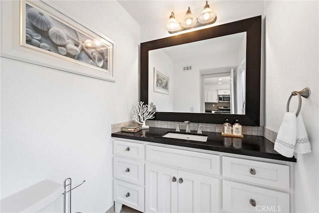 bathroom featuring tasteful backsplash and vanity