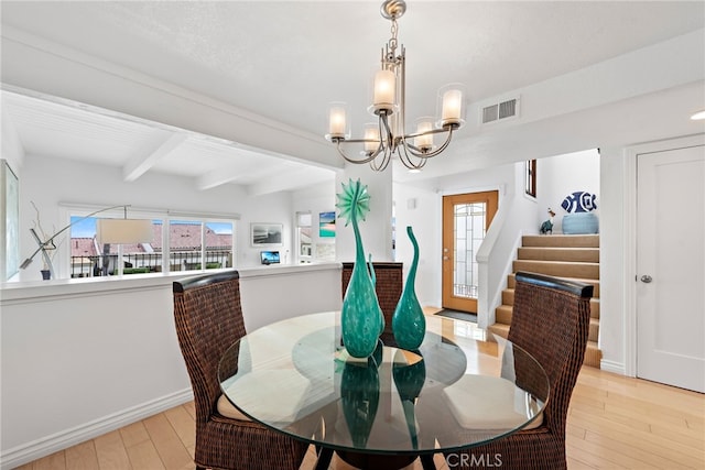 dining room featuring light wood-type flooring, a chandelier, and beam ceiling