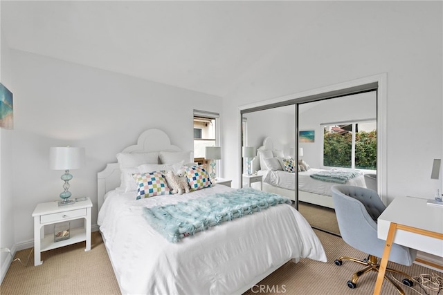 carpeted bedroom with vaulted ceiling and a closet