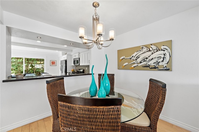 dining area featuring an inviting chandelier and light wood-type flooring