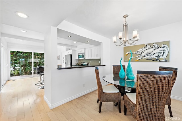 dining space with a chandelier and light hardwood / wood-style flooring