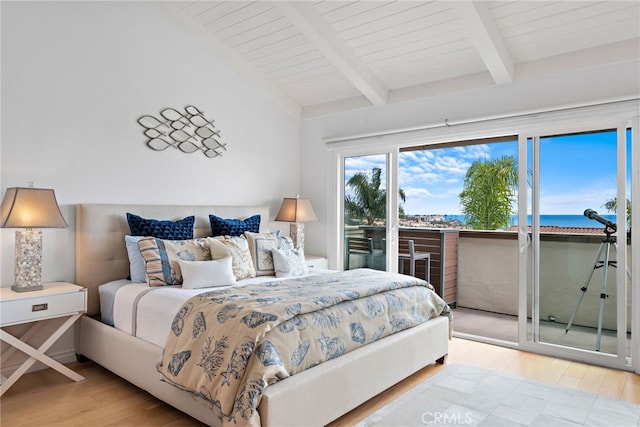 bedroom featuring beam ceiling, a water view, access to exterior, and light hardwood / wood-style floors