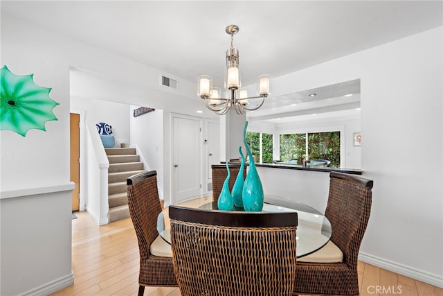 dining area featuring a notable chandelier and light hardwood / wood-style flooring