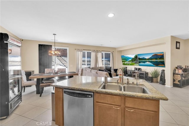 kitchen featuring pendant lighting, stainless steel dishwasher, sink, and light tile patterned floors