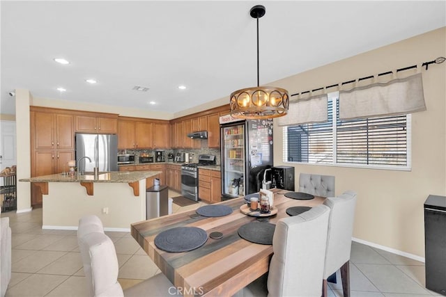 dining area featuring light tile patterned flooring, sink, and an inviting chandelier