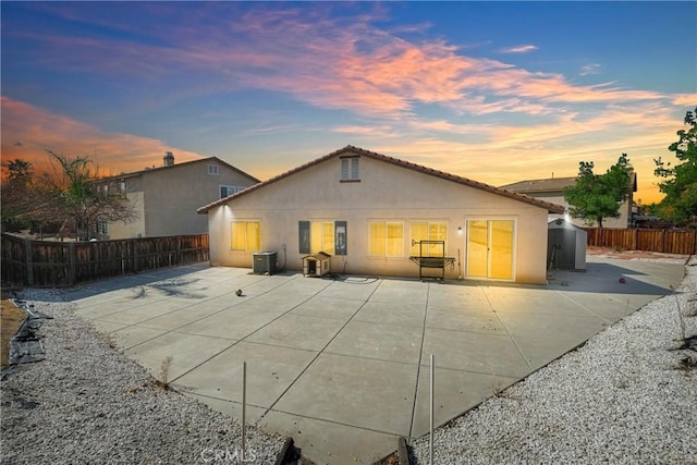 back house at dusk with a patio