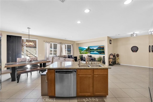 kitchen featuring light tile patterned flooring, dishwasher, sink, hanging light fixtures, and a kitchen island with sink