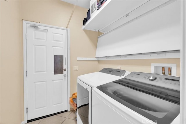 laundry area with independent washer and dryer and light tile patterned flooring