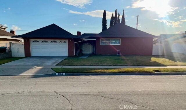 single story home featuring a garage and a front yard