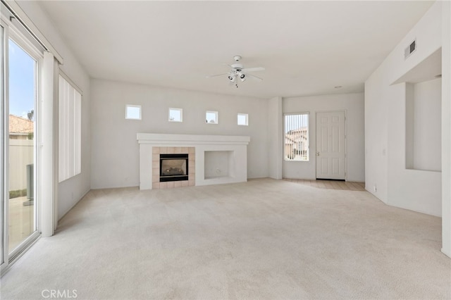 unfurnished living room with light carpet, a fireplace, and ceiling fan