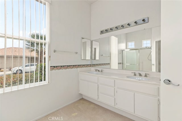 bathroom with vanity, a healthy amount of sunlight, and walk in shower