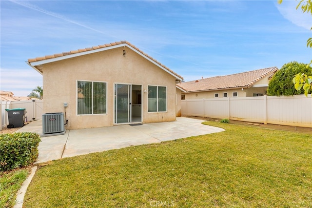 back of property featuring cooling unit, a patio area, and a lawn