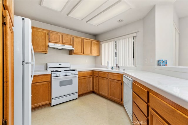 kitchen featuring sink, white appliances, and tile counters