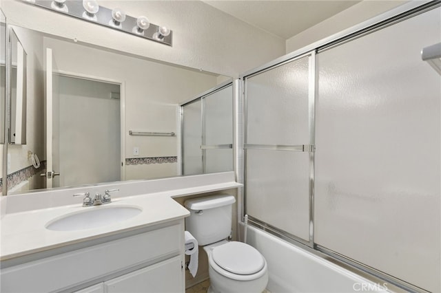 full bathroom featuring vanity, shower / bath combination with glass door, and toilet