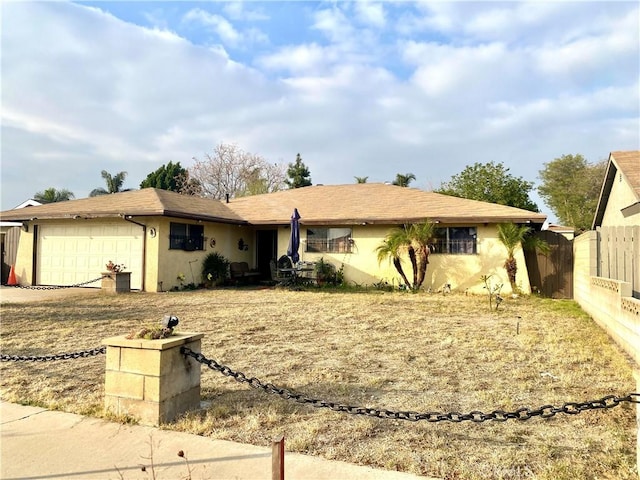 single story home featuring a garage, fence, driveway, and stucco siding