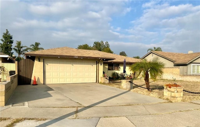 ranch-style house with a garage, driveway, and stucco siding