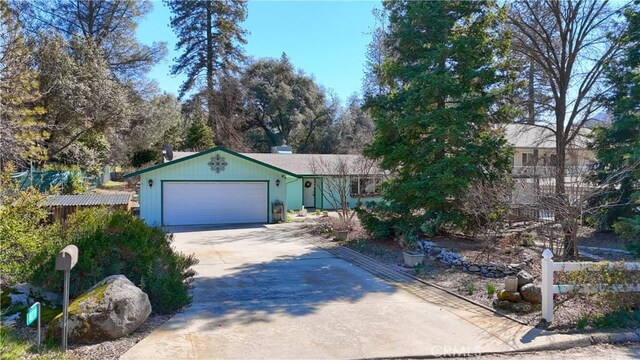 view of front of house with concrete driveway, an attached garage, and fence