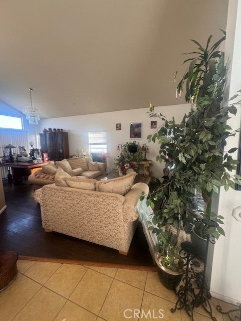 living room featuring an inviting chandelier, lofted ceiling, and light tile patterned floors