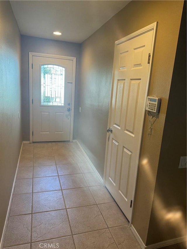 doorway to outside with light tile patterned floors