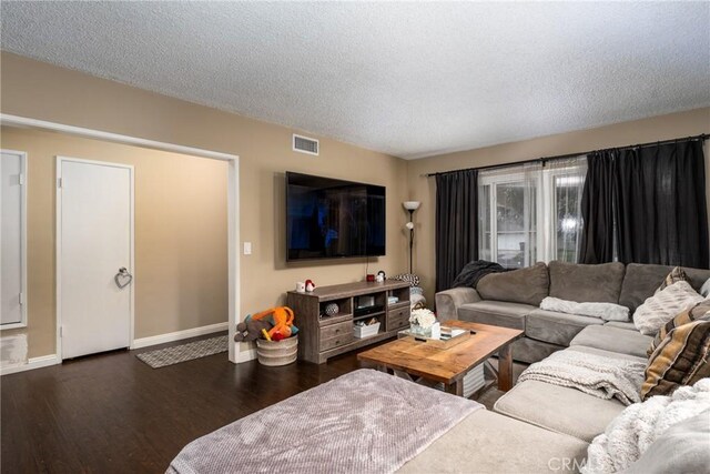 living room with dark hardwood / wood-style floors and a textured ceiling