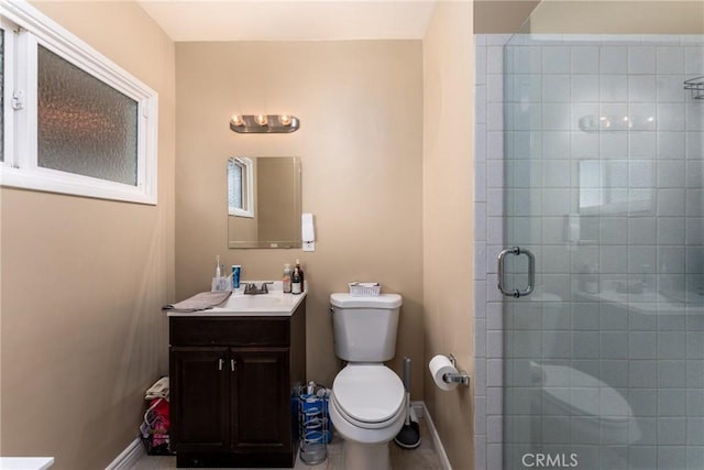 bathroom featuring vanity, toilet, and a shower with door