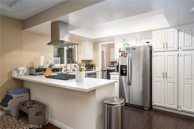 kitchen featuring appliances with stainless steel finishes, white cabinets, island exhaust hood, kitchen peninsula, and dark wood-type flooring