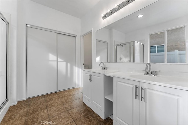 bathroom featuring a stall shower, a sink, and double vanity