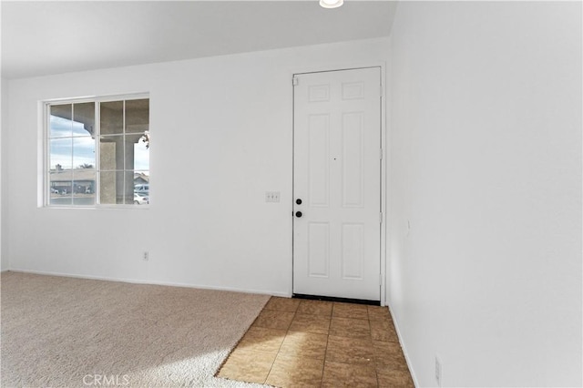 carpeted spare room featuring baseboards