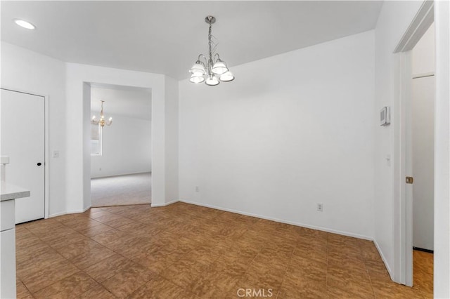 unfurnished dining area featuring a chandelier and baseboards