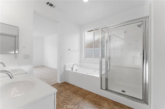 bathroom featuring a jetted tub, double vanity, visible vents, and a sink