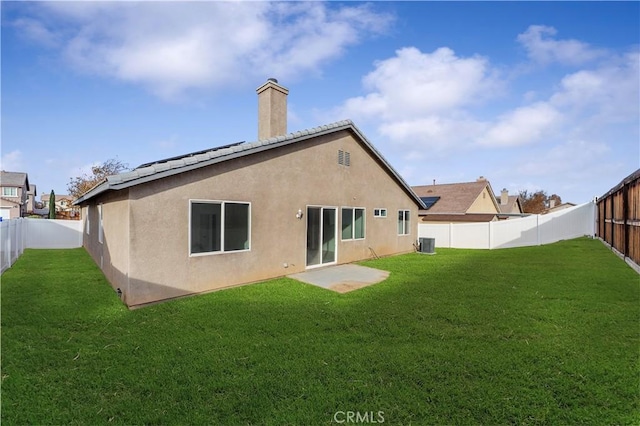 rear view of property with a yard and central air condition unit