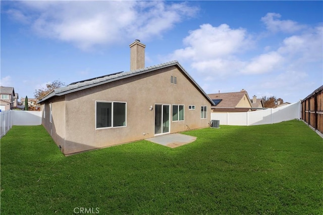 back of house featuring a fenced backyard, a lawn, and stucco siding