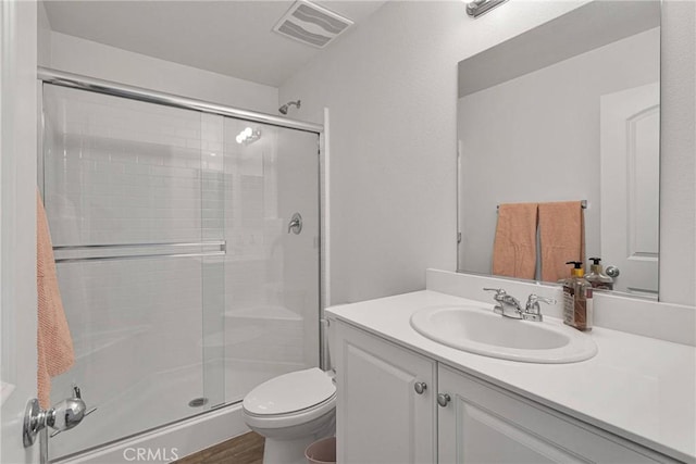 bathroom featuring vanity, hardwood / wood-style floors, toilet, and walk in shower