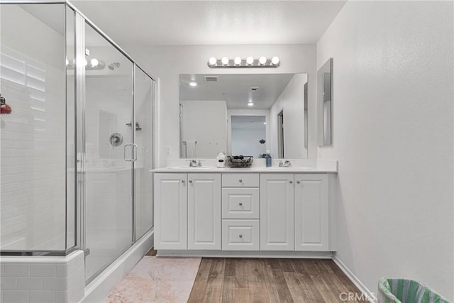 bathroom with vanity, wood-type flooring, and walk in shower