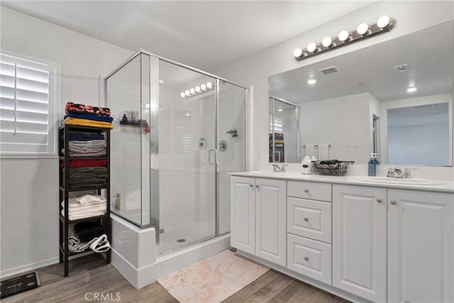 bathroom featuring vanity, hardwood / wood-style floors, and an enclosed shower