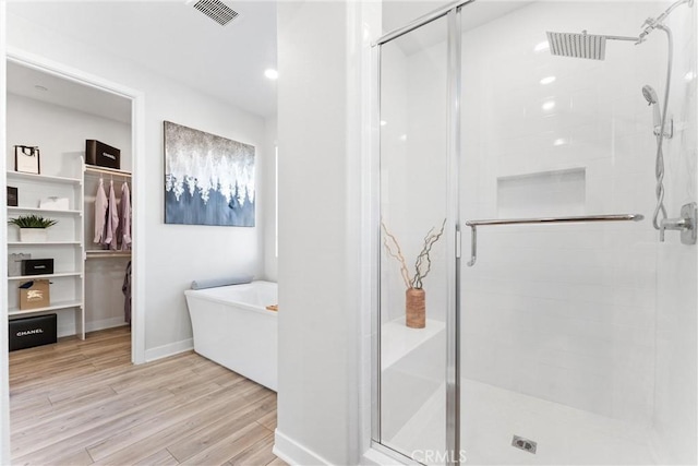 bathroom with hardwood / wood-style flooring and plus walk in shower