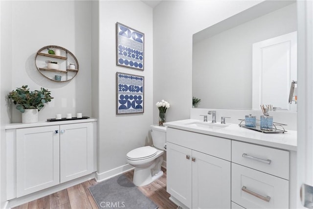 bathroom featuring vanity, wood-type flooring, and toilet