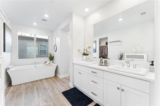 bathroom featuring vanity, hardwood / wood-style flooring, and a bathing tub