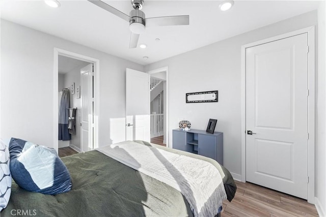 bedroom with ceiling fan, connected bathroom, and hardwood / wood-style floors