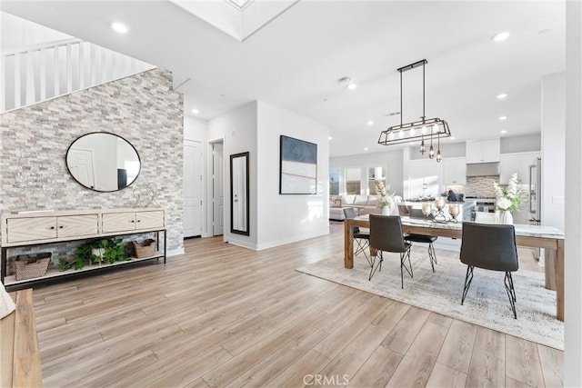 dining room featuring light hardwood / wood-style floors and a skylight